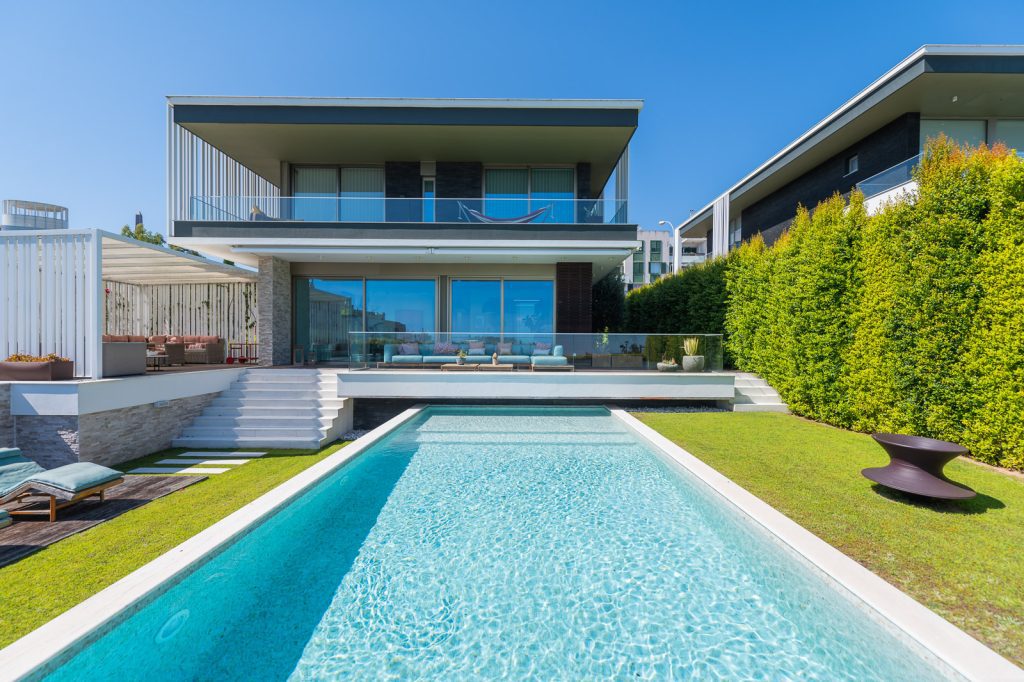 Fotografia imobiliária de moradia moderna com piscina e jardim